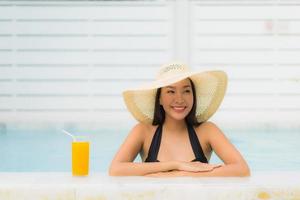 ritratto bella giovane donna asiatica sorriso felice rilassarsi intorno alla piscina all'aperto foto
