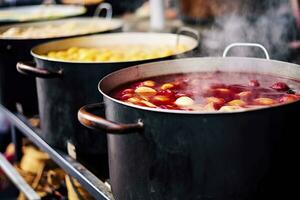 bevande frutta e frutti di bosco caldo vin brulé vino nel pentole con vapore nel strada cibo mercato. generativo ai foto