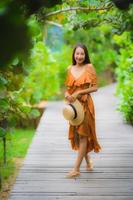 ritratto bella giovane donna asiatica cammina sul sentiero cammina nel giardino foto