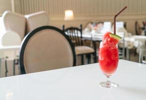 bicchiere di frullato di anguria fresca sul tavolo nel ristorante caffetteria foto
