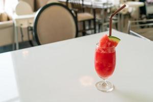 bicchiere di frullato di anguria fresca sul tavolo nel ristorante caffetteria foto
