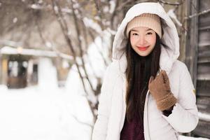 bella giovane donna asiatica sorridente felice per il viaggio nella stagione invernale della neve foto