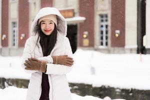 bella giovane donna asiatica sorridente felice per il viaggio nella stagione invernale della neve