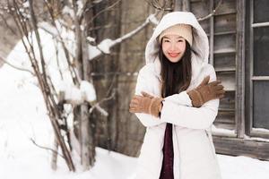 bella giovane donna asiatica sorridente felice per il viaggio nella stagione invernale della neve foto