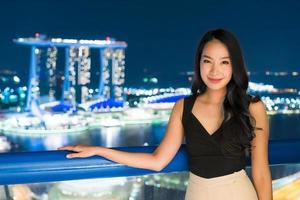 le belle donne asiatiche sorridono e sono felici con la vista della città di Singapore foto