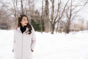 bella giovane donna asiatica sorridente felice per il viaggio nella stagione invernale della neve foto