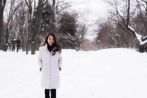 bella giovane donna asiatica sorridente felice per il viaggio nella stagione invernale della neve foto