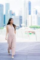 bella donna asiatica sorride e felice di viaggiare nella città di singapore foto