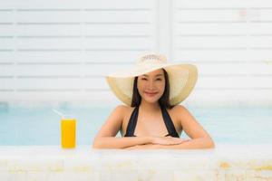 ritratto bella giovane donna asiatica sorriso felice rilassarsi intorno alla piscina all'aperto foto