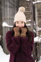 bella giovane donna asiatica sorridente felice per il viaggio nella stagione invernale della neve foto