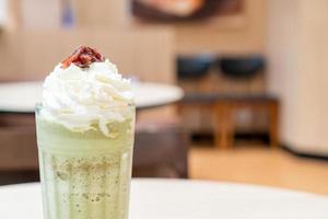 tè verde matcha latte miscelato con panna montata e fagioli rossi nella caffetteria bar e ristorante foto