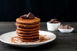 pila di pancake al cioccolato con cioccolato in polvere foto