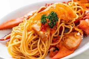 spaghetti all'aragosta con uovo di gamberi su piatto bianco foto