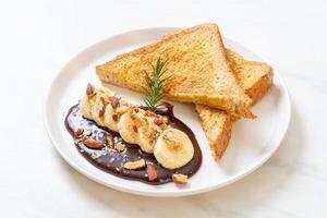 French toast con banana, cioccolato e mandorle a colazione foto
