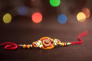 sfondo raksha bandhan con un elegante rakhi. un tradizionale cinturino da polso indiano che è un simbolo di amore tra fratelli e sorelle. foto