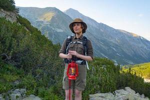 giovane donna viaggiatrice con zaino in montagna foto