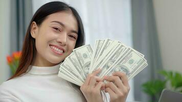 asiatico libero professionista donna conteggio i soldi nel casa. foto