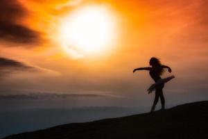 silhouette ballerina, ballare da solo nella natura in montagna al tramonto foto