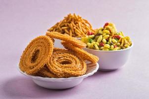 snack indiano chakli, chakali o murukku e farina di ceci besan sev e chivada o chiwada su sfondo rosa. cibo diwali foto
