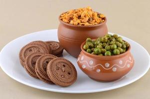 miscela indiana di snack, biscotto alla crema e piselli fritti speziati, chatpata matar nel piatto. foto