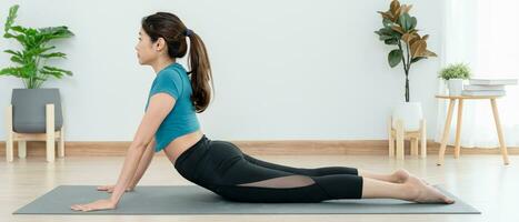 sottile donna praticante yoga su camera di sua condominio o casa. asiatico donna fare esercizi nel mattina. equilibrio, meditazione, rilassamento, calma, bene Salute, felice, relax, salutare stile di vita, dieta, sottile foto