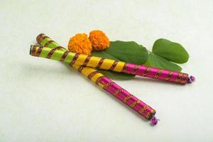 festival indiano dussehra, con foglie d'oro bauhinia racemosa e fiori di calendula con bastoncini dandiya. foto