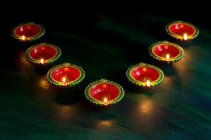 felice diwali - lampade diya in argilla accese durante la celebrazione del diwali. biglietto di auguri design del festival della luce indù indiano chiamato diwali foto