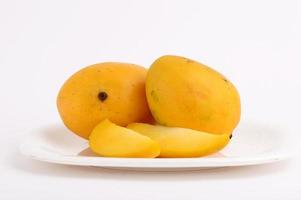 Frutto di mango in cesto con fetta su sfondo bianco foto