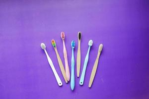 spazzolini da denti colorati su sfondo viola, vista dall'alto foto