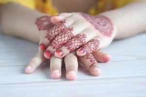 mano della ragazza del bambino con mehendi sul tavolo, foto