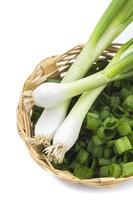 cipolline verdi mature fresche, scalogno o scalogno con cipolle tritate nel cesto su sfondo bianco