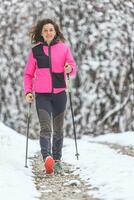 un' giovane donna passeggiate nel nevoso sentiero foto