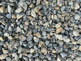 pietre su il mare spiaggia, roccia struttura, minerale strada sfondo, vario ciottoli ghiaia sfondo foto