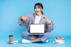 studentessa asiatica con espressione giocosa su sfondo blu foto