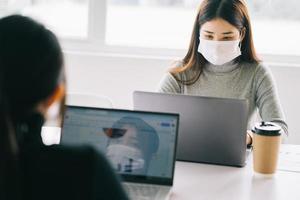 due donne devono indossare maschere durante l'orario di lavoro per stare al sicuro durante le epidemie