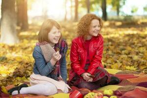 Due amiche nel il autunno parco a un' picnic. bambini nel autunno. foto