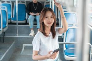 donna asiatica che utilizza smartphone sull'autobus? foto