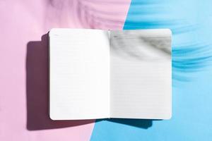 libro aperto bianco su sfondo blu e rosa, concetto estivo foto