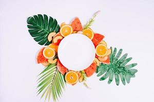 il piatto vuoto è posto su pezzi di frutta tropicale foto