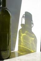 vuoto bicchiere vino bottiglia verde ombra su parete. alcool bevanda luce solare riflessione. silhouette su superficie. verticale fotografia per striscione, manifesto, sbarra, ristorante, cartello, volantino. foto