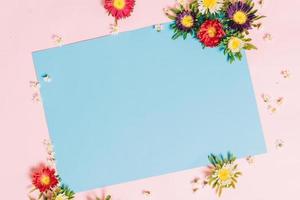 la carta blu è posta su uno sfondo rosa con fiori intorno a hoa