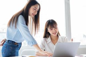 donna d'affari asiatica e colleghi che discutono di lavorare insieme foto