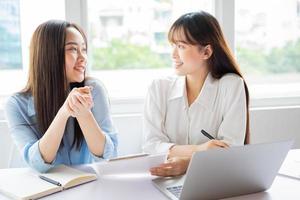 donna d'affari asiatica e colleghi che discutono di lavorare insieme foto