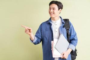 una foto di un bel studente asiatico che indica con il dito