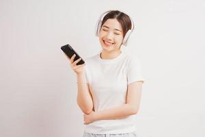 giovane ragazza asiatica che tiene il suo telefono ascoltando musica foto
