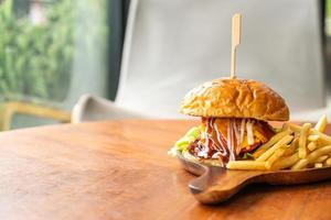 hamburger di manzo con formaggio e salsa su piatto di legno