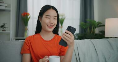 giovane asiatico donna video chiamata con amico su mobile Telefono foto