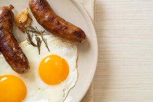 doppio uovo fritto fatto in casa con salsiccia di maiale fritta - per colazione foto