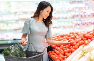 la ragazza sceglie di comprare la verdura al supermercato foto