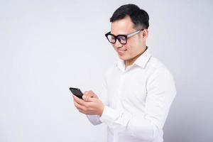 uomo d'affari asiatico che utilizza smartphone su sfondo bianco